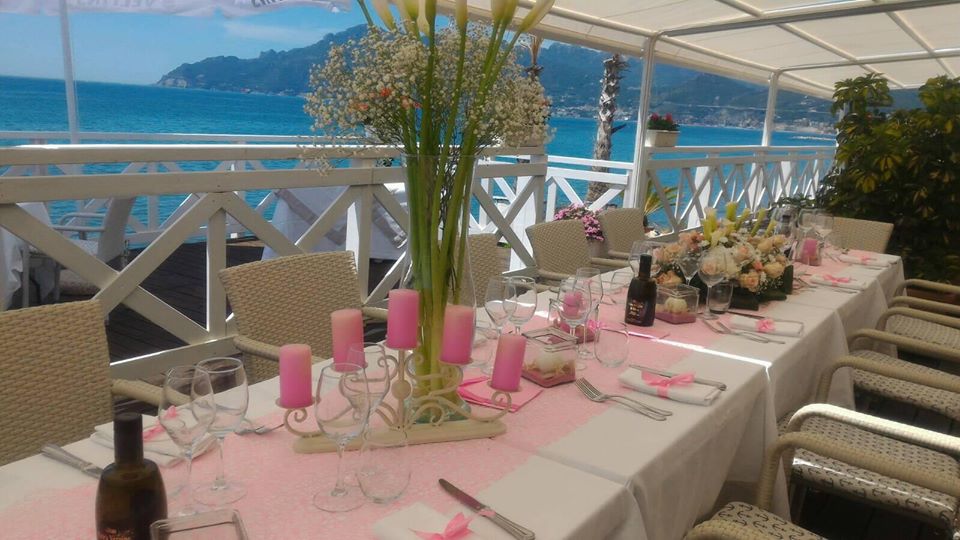 Tavolo cerimonia con vista mare e centrotavola floreale